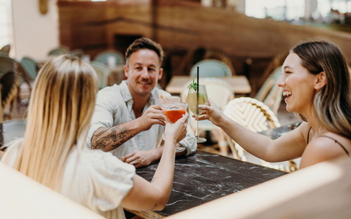 three people enjoying cocktail